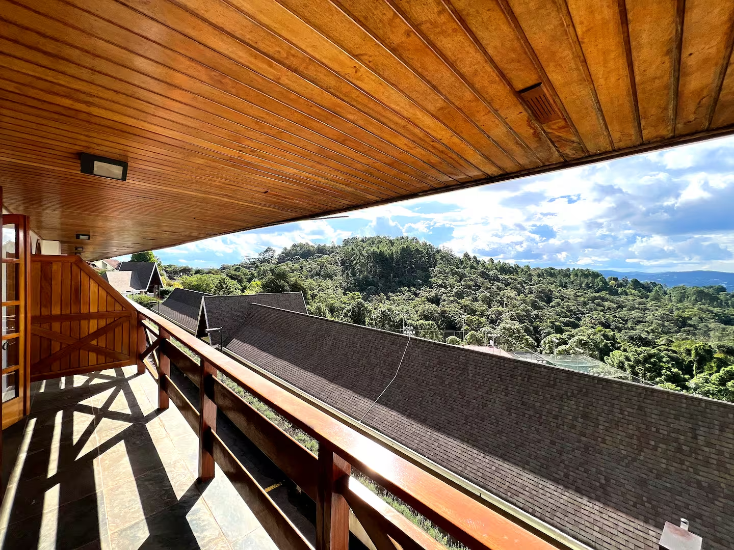 Varanda com vista ampla para a natureza em imóvel de temporada
